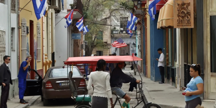Personas transitan por una calle decorada con banderas de Cuba, en La Habana (Cuba). EFE/ Ernesto Mastrascusa.