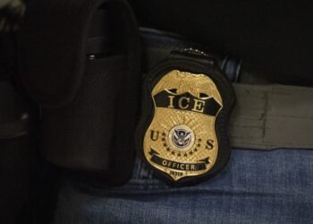 Un agente federal lleva una placa del Servicio de Inmigración y Control de Aduanas mientras permanece afuera de una sala del tribunal de inmigración en el edificio federal Jacob K. Javits en Nueva York, el martes 10 de junio de 2025. Créditos: Yuki Iwamura / Foto AP